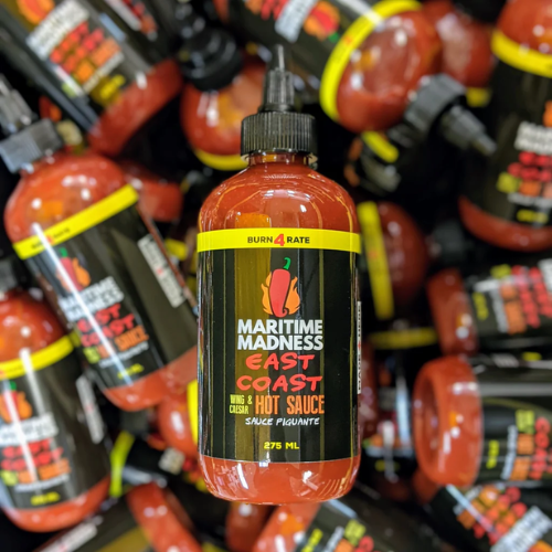 Maritime Madness East Coast Hot Sauce bottle in a store setting with other hot sauce bottles.
