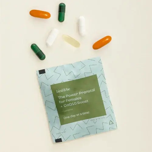Prenatal supplement package with colorful capsules on a light background