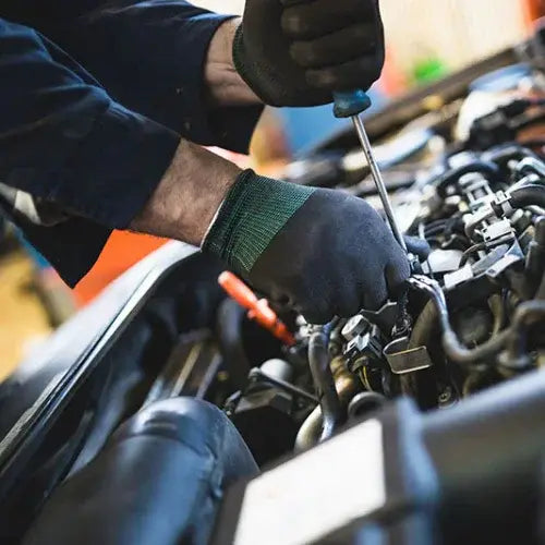 Person working on a car engine with tools