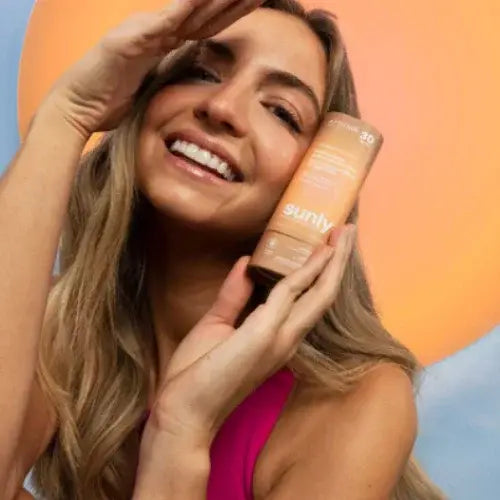 Woman holding a sun protection product with a colorful background