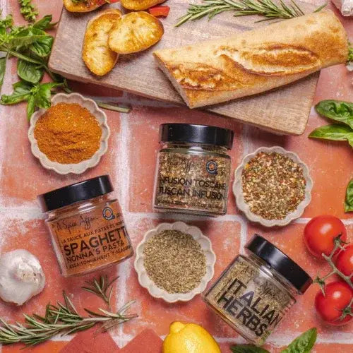 Spices and herbs with ingredients on a wooden board and red surface