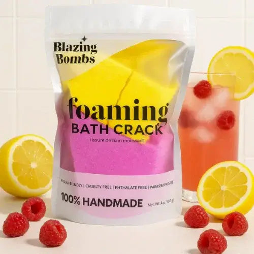 Bag of Blazing Bombs foaming bath crack with lemons, raspberries, and a glass of pink lemonade.