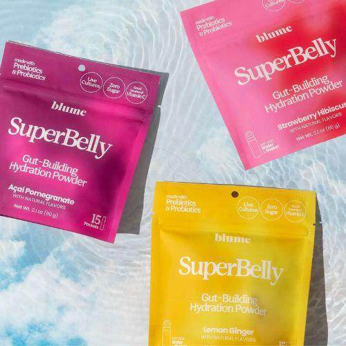 Blume SuperBelly Gut-Building Hydration Powder in Acai Pomegranate, Strawberry Hibiscus, and Lemon Ginger flavours displayed poolside under sunlight