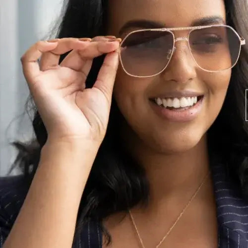 Person wearing sunglasses with a focus on the glasses.