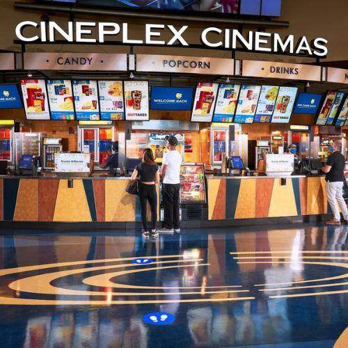 People ordering snacks at the concession stand inside a Cineplex Cinemas theatre