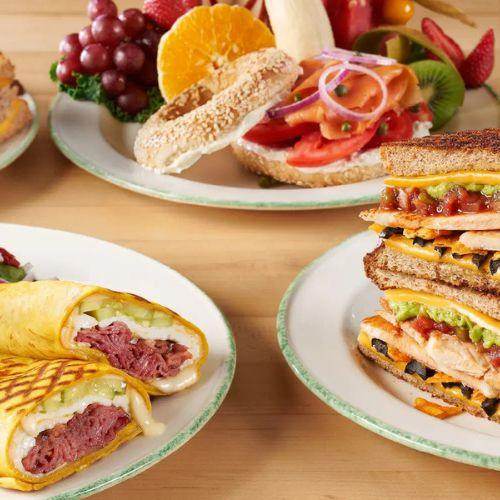 Cora Breakfast and Lunch assorted plates featuring bagels, fruit, sandwiches, and wraps – vibrant Canadian-owned breakfast restaurant