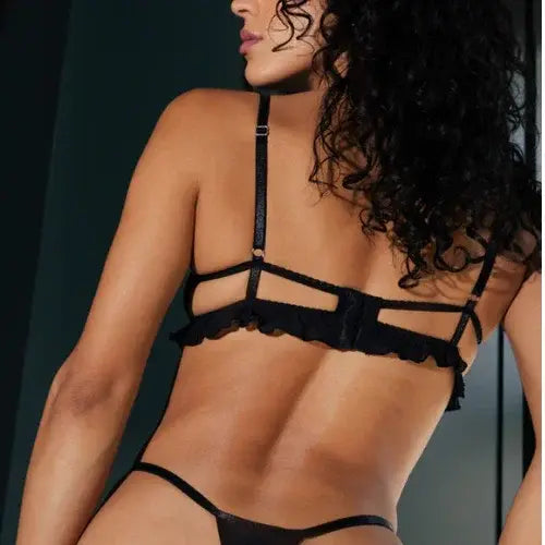 Black lingerie set with straps and mesh details on a model.