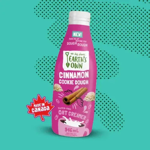 Pink bottle of Earth's Own Cinnamon Cookie Dough Oat Creamer on a teal background