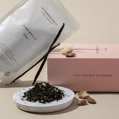 Firebelly Tea packaging with tea leaves and vanilla beans on a beige background