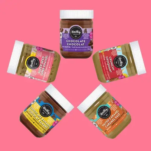 Five jars of different types of spread on a pink background