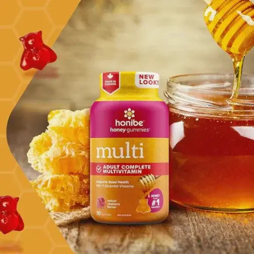 Honibe honey gummies multivitamin bottle with honeycomb and honey jar on a wooden surface