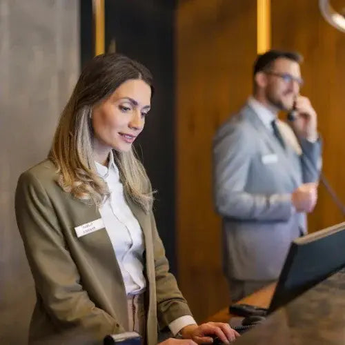Hotel front desk staff assisting guests with check-in at reception
