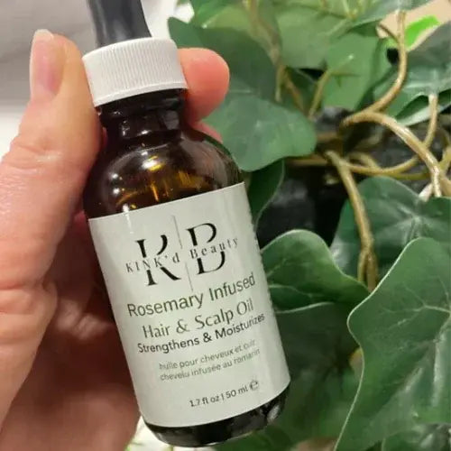 Hand holding a bottle of rosemary infused hair and scalp oil from Canadian-owned Kinkd Beauty
