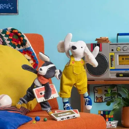Two plush toys, a badger and a dog, in a room with a boombox and colorful decor.