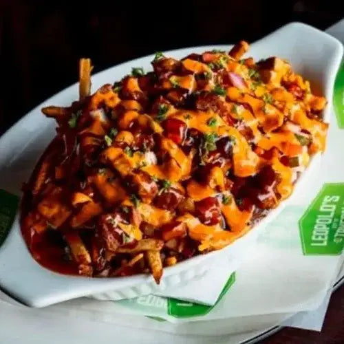 Stack of loaded fries in a branded container on a dark background