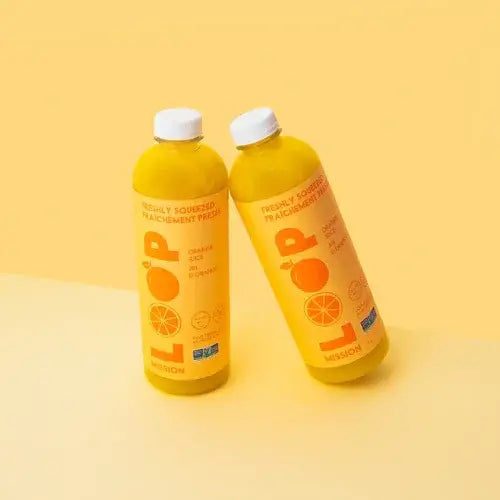 Two bottles of Loop Mission orange juice on a yellow background