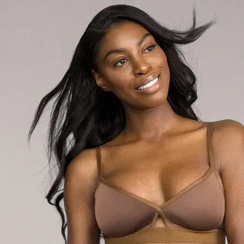 Woman wearing a sheer brown bralette against a neutral background