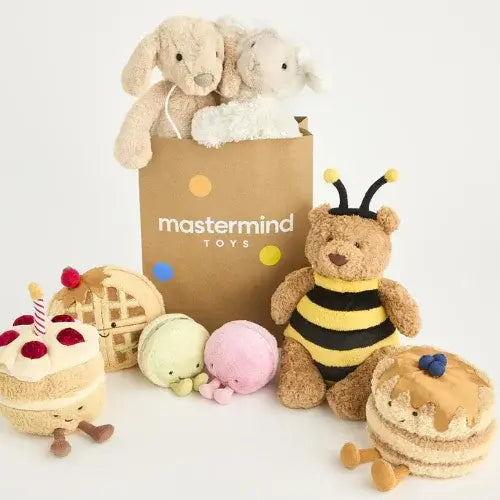 Plush toys including a bear in a bee costume, a cake, and other items with a 'mastermind TOYS' bag in the background.