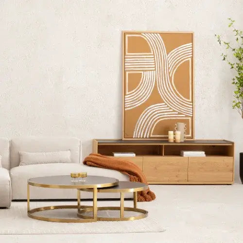 Modern living room with a gold coffee table, wooden console, and abstract wall art.