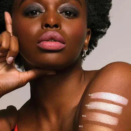Model showcasing bold lip colour and highlighter swatches on arm – Inclusive, cruelty-free makeup by Canadian-owned MOB Beauty