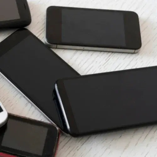 Multiple smartphones laid out on a surface.