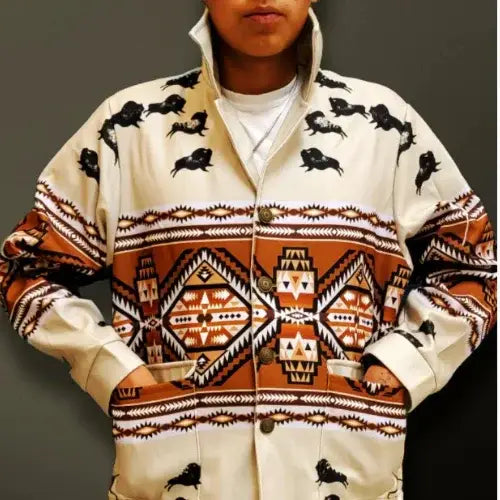 Person wearing a patterned jacket with black animals and geometric designs on a plain background