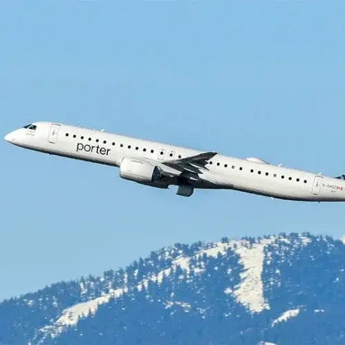 Porter Airlines aircraft ascending with snow-capped mountains in the background