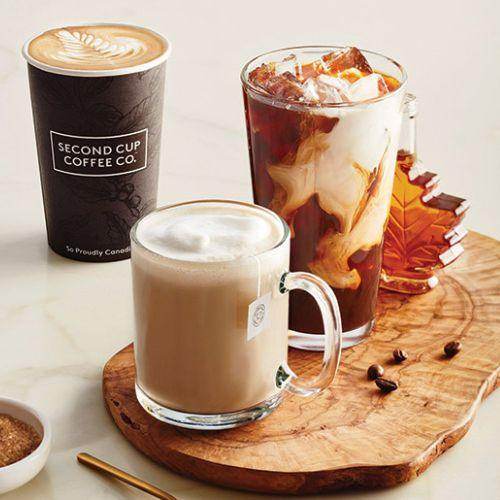 Second Cup Coffee Co. hot latte, iced coffee, and cappuccino on wooden tray with autumn decor