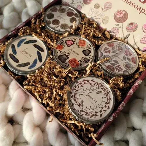 Set of decorative tins with floral designs in a gift box on a soft white background