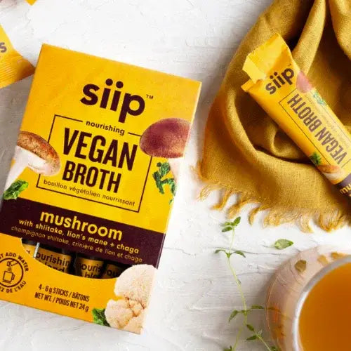 siip vegan broth package and sticks on a white surface with a yellow cloth.
