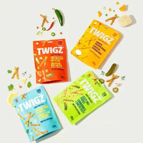 Four TWIGZ snack packages in different flavors on a white background with snacks around them.