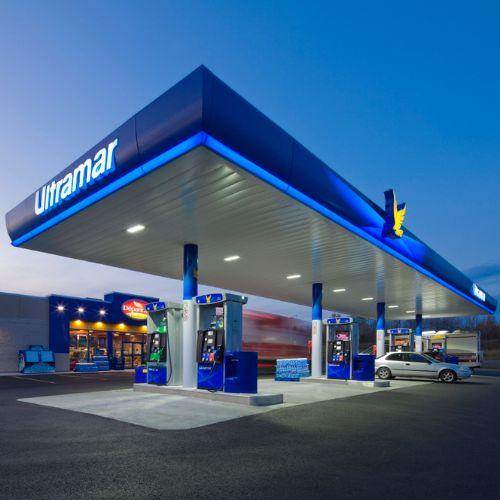 Ultramar gas station at dusk with blue-lit canopy and fuel pumps – Canadian-owned fuel and convenience brand