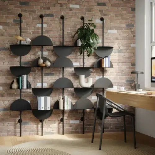Modern black wall-mounted shelf unit against a brick wall in a home office.