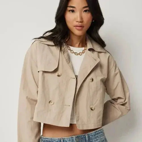 Ardene cropped beige trench-style jacket with double-breasted buttons, worn over white crop top and jeans
