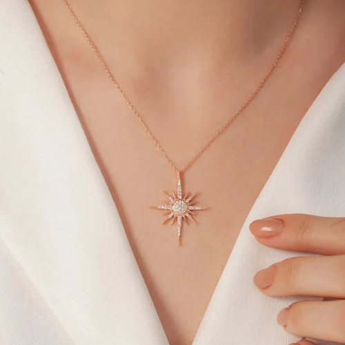 Rose gold necklace with a star-shaped pendant on a white background