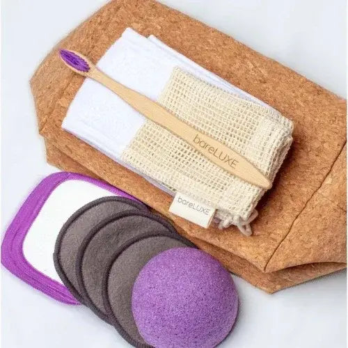 bareLUXE sustainable skincare set with bamboo toothbrush, reusable facial pads, konjac sponge, and mesh wash bag on cork packaging