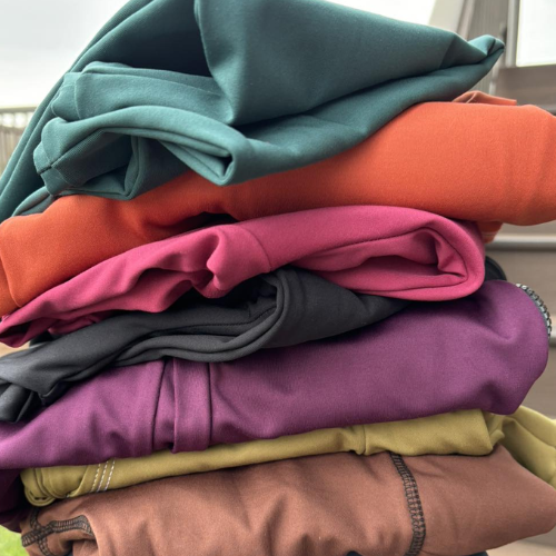 Stack of folded colourful clothes on a windowsill