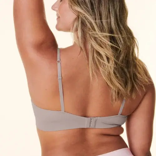 Woman wearing a beige bra against a white background