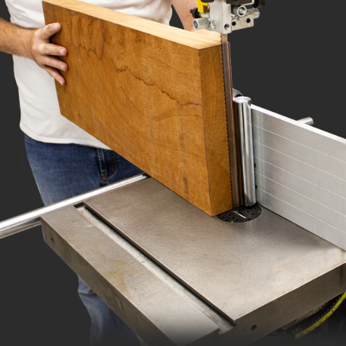 Person using a band saw to cut a piece of wood.