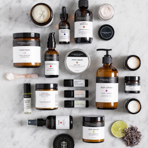 Assorted skincare and body care products on a marble surface