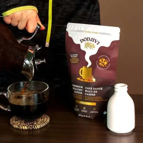 Person pouring coffee into a cup with a Dodjivi coffee bag in the background