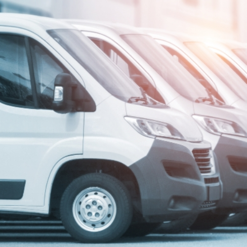Two white vans parked side by side with a blurred background