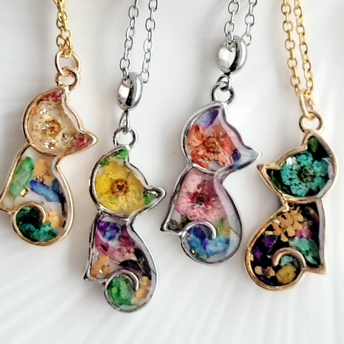 Four cat pendants in a row on gold and silver chains