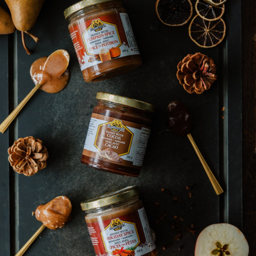 Dutchman’s Gold honey jars in holiday flavours on a dark tray with seasonal decor