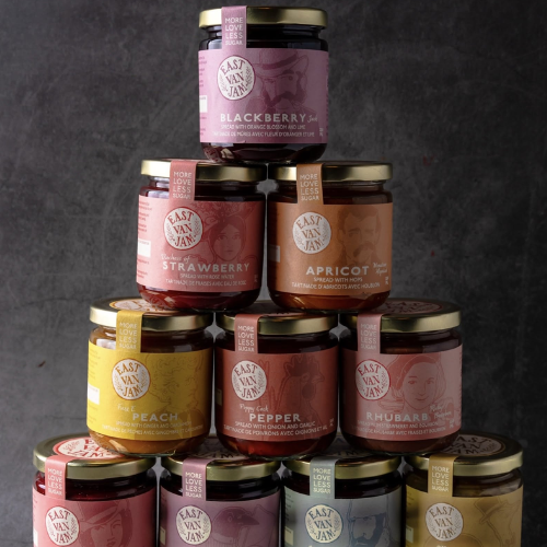 Stack of East Van Jam jars with various flavours on a dark background