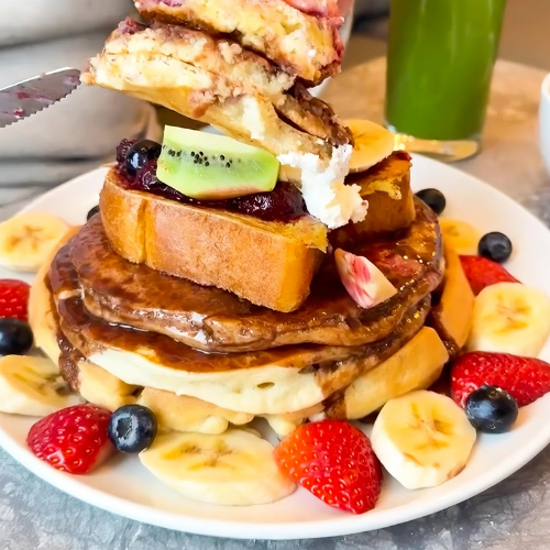 Stack of pancakes with fruit on a plate