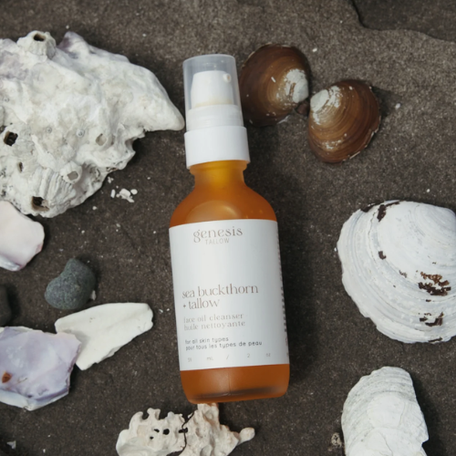 Skincare bottle labelled 'genesis' on a textured surface with shells