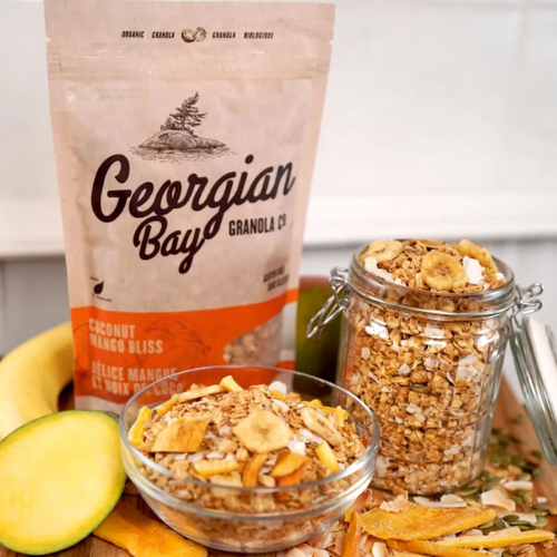 Georgian Bay Granola Co. coconut mango bliss granola with packaging, jar, and bowl on a white background