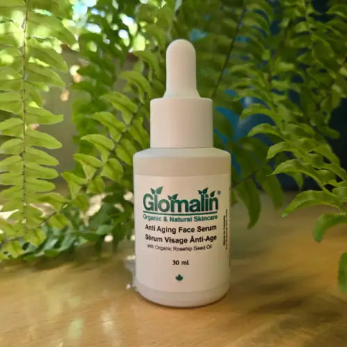 Glomalin anti-aging face serum bottle on a wooden surface with green leaves in the background
