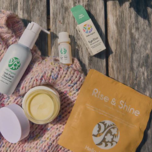 Skincare products and a 'Rise & Shine' packet on a textured surface
